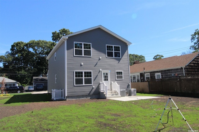 back of house with central AC unit and a yard