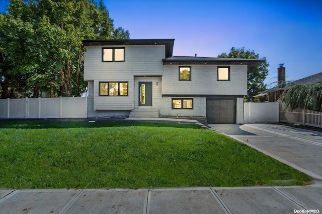 view of front of home with a yard and a garage