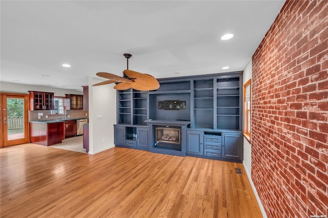 bar with brick wall, stainless steel dishwasher, and light wood-type flooring