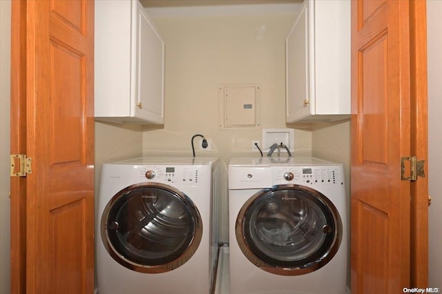 laundry area featuring electric panel, cabinets, and washing machine and dryer