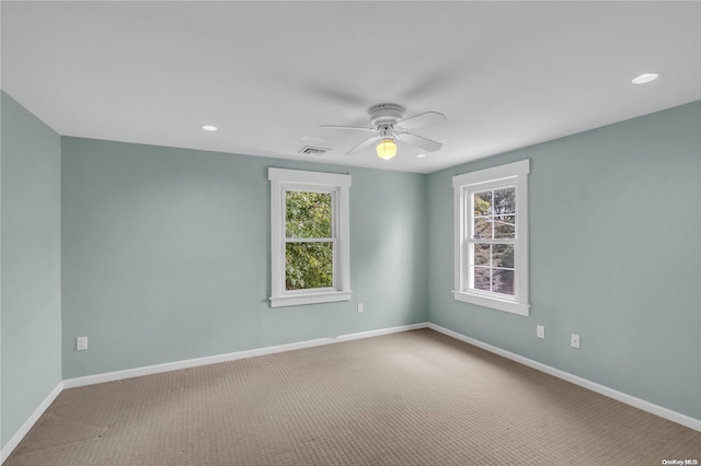 carpeted spare room with a healthy amount of sunlight and ceiling fan