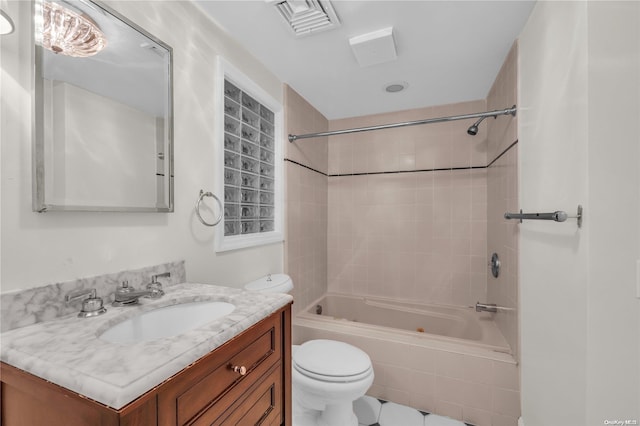 full bathroom with toilet, vanity, and tiled shower / bath