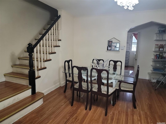 dining area featuring a notable chandelier, crown molding, and dark wood-type flooring