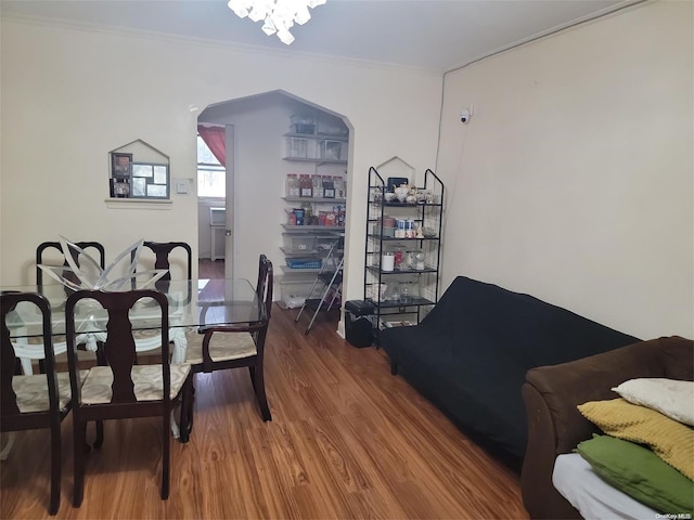 dining space featuring hardwood / wood-style floors, a chandelier, and ornamental molding