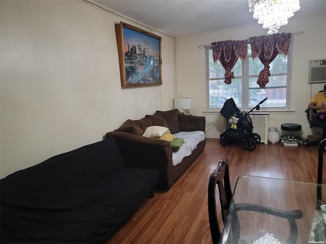 living room featuring hardwood / wood-style floors, a wall mounted air conditioner, and a notable chandelier