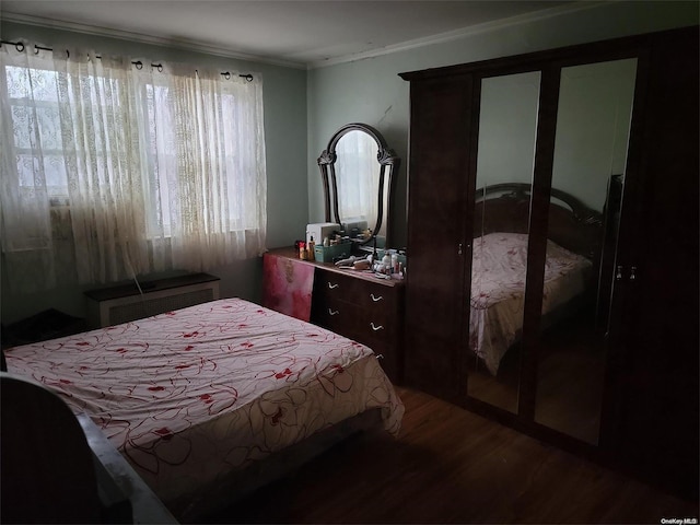 bedroom with radiator, wood-type flooring, and ornamental molding