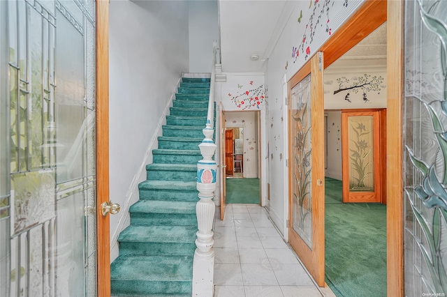 stairs with carpet floors and ornamental molding