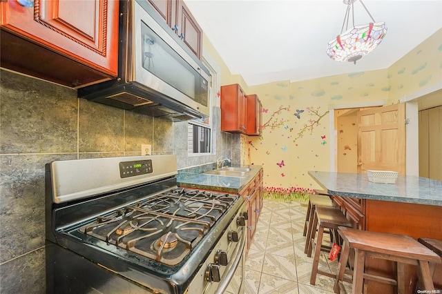 kitchen featuring pendant lighting, sink, stainless steel appliances, and tasteful backsplash