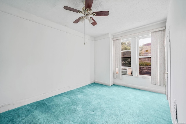 carpeted empty room featuring ceiling fan and a textured ceiling