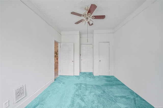 carpeted empty room featuring ceiling fan