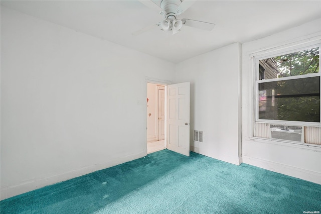 carpeted spare room featuring ceiling fan and cooling unit