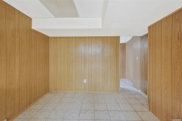 tiled spare room featuring wooden walls