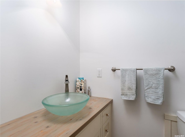 bathroom featuring toilet, vanity, and hardwood / wood-style flooring