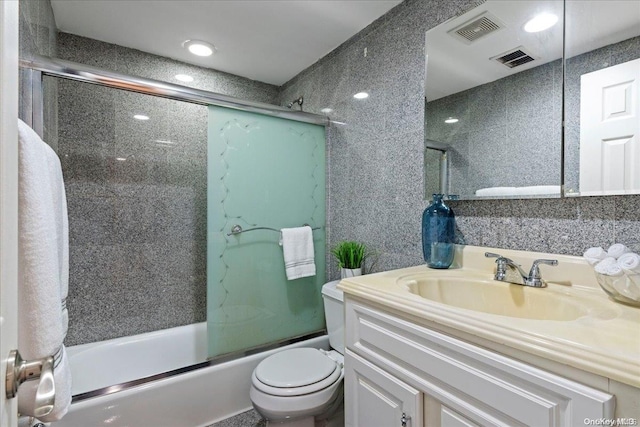 full bathroom with shower / bath combination with glass door, vanity, and toilet