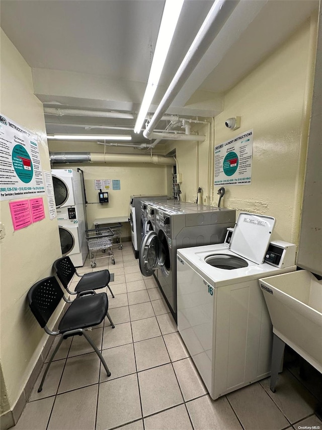 laundry room featuring washer and dryer, light tile patterned floors, stacked washer and dryer, and sink