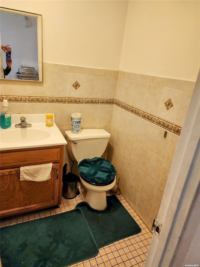 bathroom with tile patterned floors, vanity, tile walls, and toilet