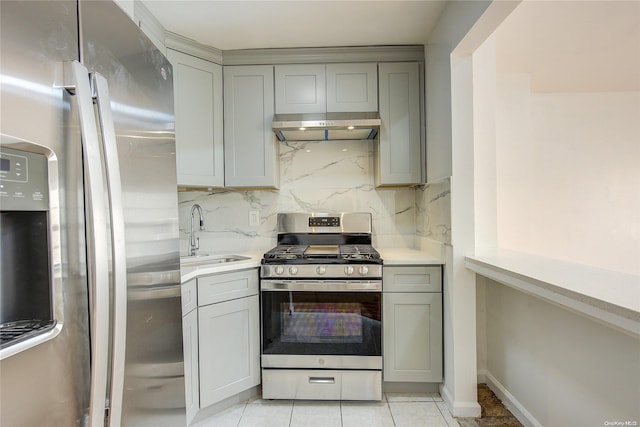 kitchen with sink, light tile patterned floors, range hood, tasteful backsplash, and stainless steel appliances