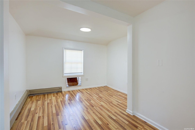 spare room with a baseboard radiator and light wood-type flooring