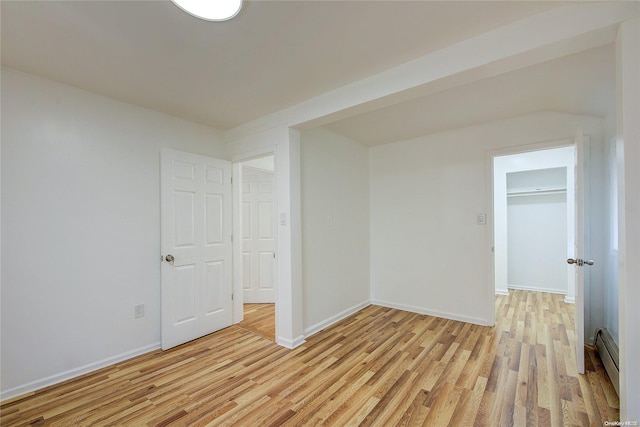 unfurnished room featuring light hardwood / wood-style floors and baseboard heating