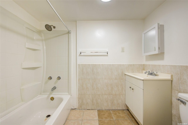 full bathroom with tiled shower / bath combo, tile patterned floors, toilet, vanity, and tile walls