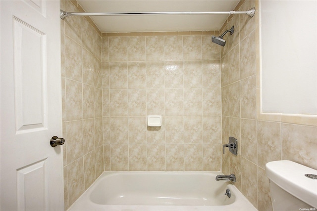 bathroom with toilet, tile walls, and tiled shower / bath