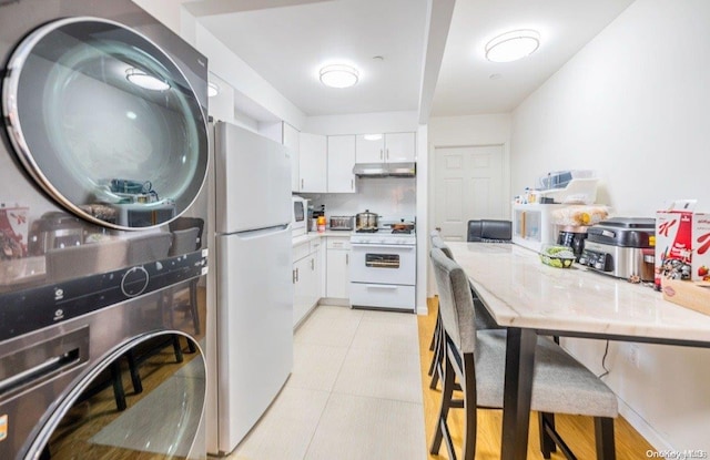 kitchen with white cabinetry, white appliances, and light tile patterned floors