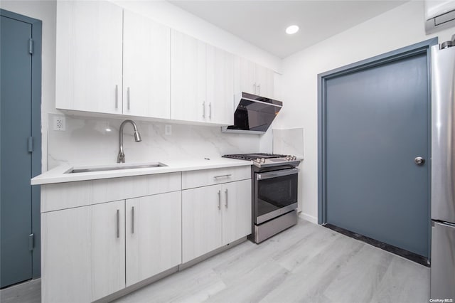 kitchen with light wood-type flooring, sink, white cabinetry, and stainless steel gas range