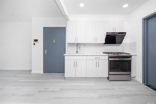 kitchen with sink, tasteful backsplash, light hardwood / wood-style floors, stainless steel range oven, and white cabinetry