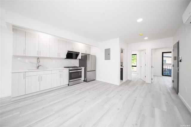 kitchen with sink, light hardwood / wood-style floors, extractor fan, white cabinets, and appliances with stainless steel finishes