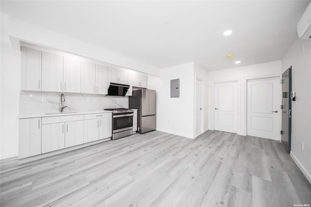 kitchen featuring white cabinets, appliances with stainless steel finishes, light hardwood / wood-style floors, and sink