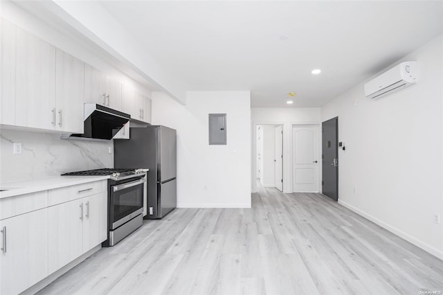 kitchen featuring stainless steel appliances, tasteful backsplash, a wall unit AC, electric panel, and light hardwood / wood-style floors