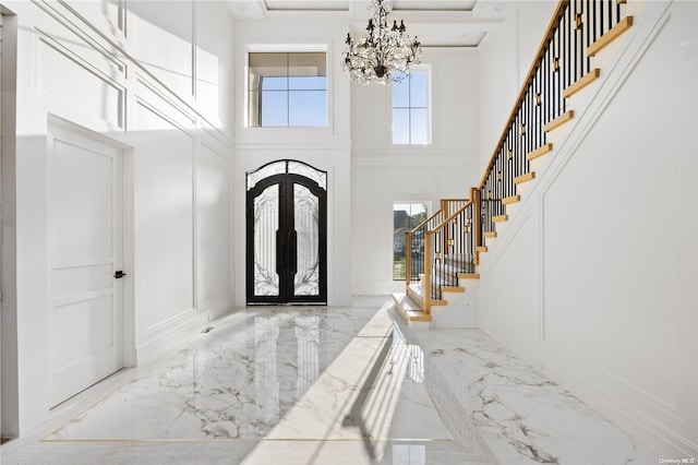 entryway featuring french doors, a high ceiling, and an inviting chandelier