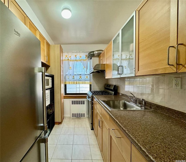 kitchen with dark stone counters, sink, light tile patterned floors, tasteful backsplash, and stainless steel appliances