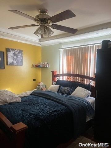 bedroom with ceiling fan and ornamental molding