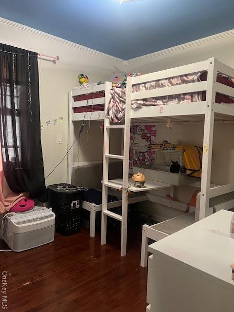 bedroom with dark wood-style floors and crown molding