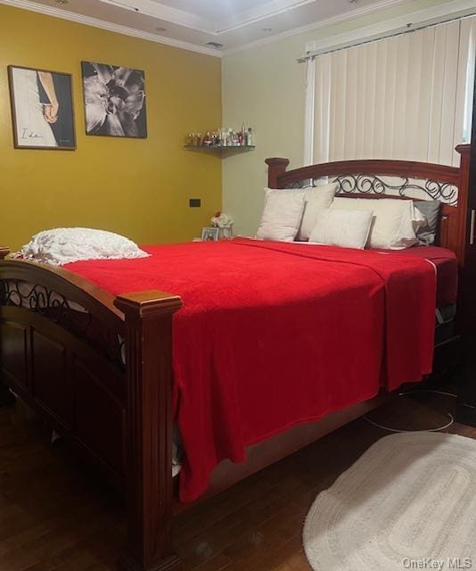 bedroom featuring ornamental molding and dark wood finished floors