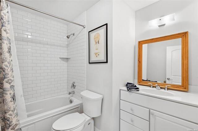 full bathroom with vanity, shower / bath combination with curtain, and toilet