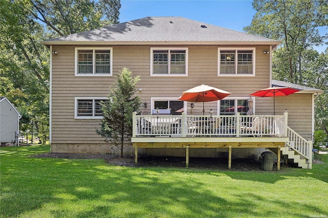 rear view of property featuring a lawn and a wooden deck