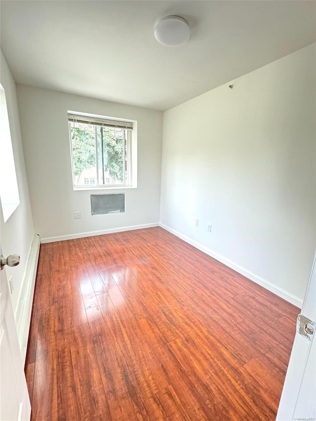 spare room featuring dark hardwood / wood-style floors and a baseboard heating unit