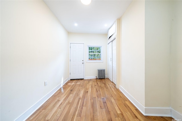 hallway with radiator heating unit and light wood-type flooring