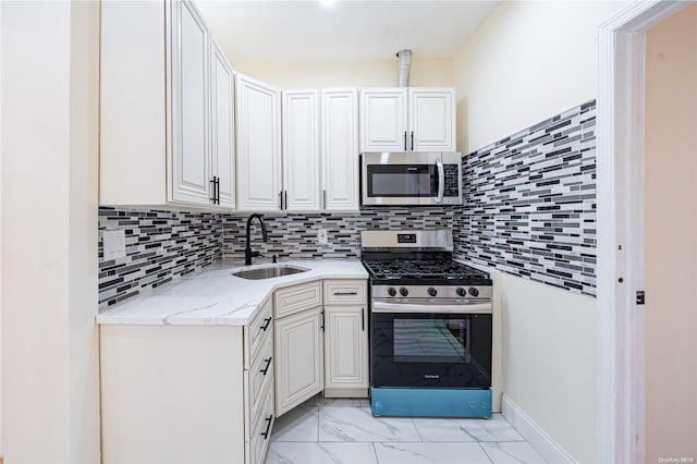 kitchen with white cabinets, sink, appliances with stainless steel finishes, and tasteful backsplash