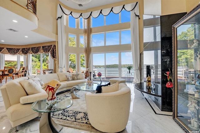 living room with a water view, a wealth of natural light, and a towering ceiling