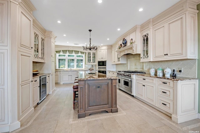 kitchen featuring a center island, hanging light fixtures, stainless steel appliances, wine cooler, and light stone counters