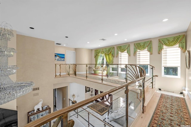 corridor with a notable chandelier and light hardwood / wood-style floors