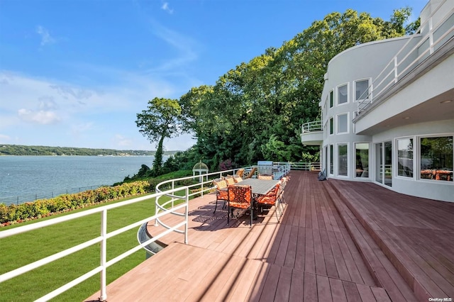 wooden deck featuring a lawn and a water view