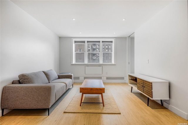 living room with light hardwood / wood-style flooring and a baseboard heating unit