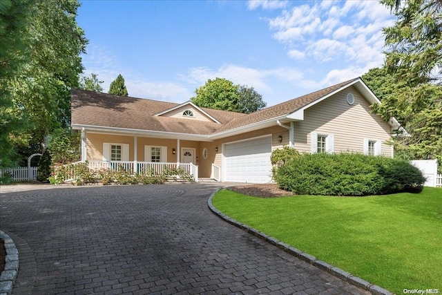 single story home featuring a front yard, a porch, and a garage