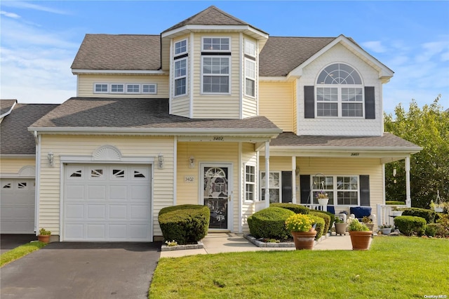 view of front of property featuring a porch, a garage, and a front lawn