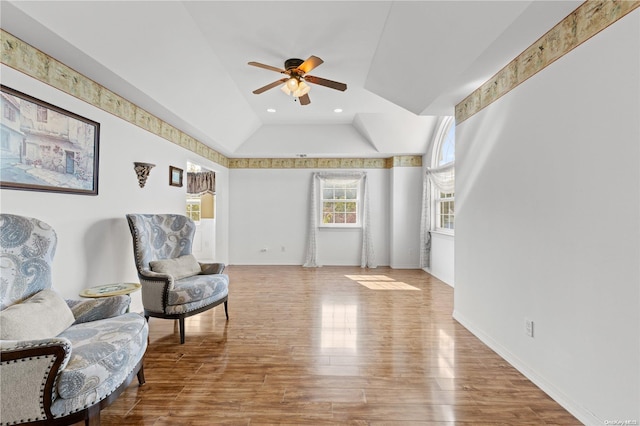 living area featuring light hardwood / wood-style floors, ceiling fan, and lofted ceiling