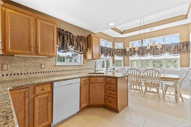 kitchen with a notable chandelier, dishwasher, a wealth of natural light, and a tray ceiling